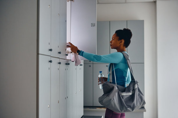 非裔美国运动员在健身房锻炼后从储物柜里拿东西。图片下载