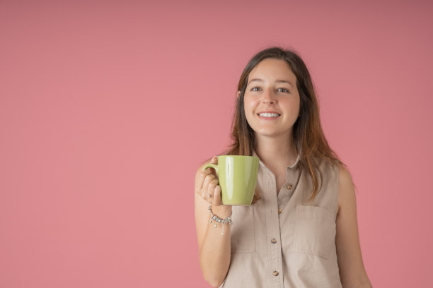 年轻女人手捧茶杯微笑图片下载