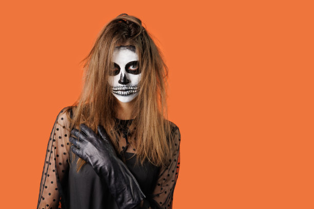 年轻的棕色头发的女孩与万圣节艺术在工作室摆姿势。万圣节庆祝概念。图片下载