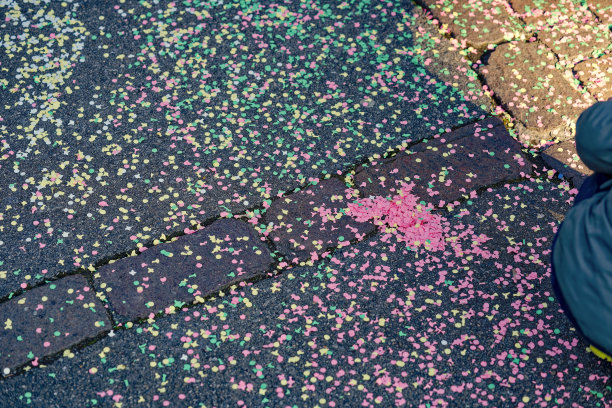 Children carnival of crèches with colorful confetti on the floor at City of Zürich district Schwamendingen on a sunny winter day.图片下载
