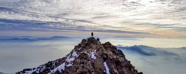 一个男人站在山顶的航拍照片图片下载