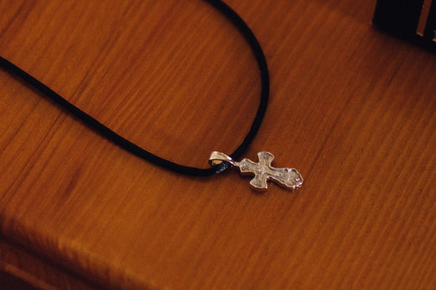 近距离拍摄一个银色的基督十字架放在木桌上图片下载
