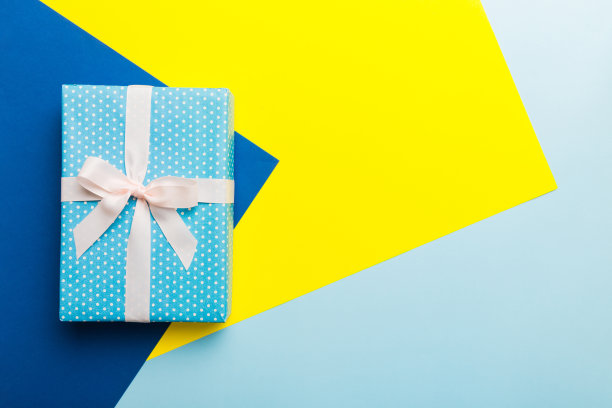 假日手工纸礼物系白丝带蝴蝶结顶视图与复制空间。平铺假日背景。生日或圣诞礼物。圣诞礼盒概念与复制空间图片下载