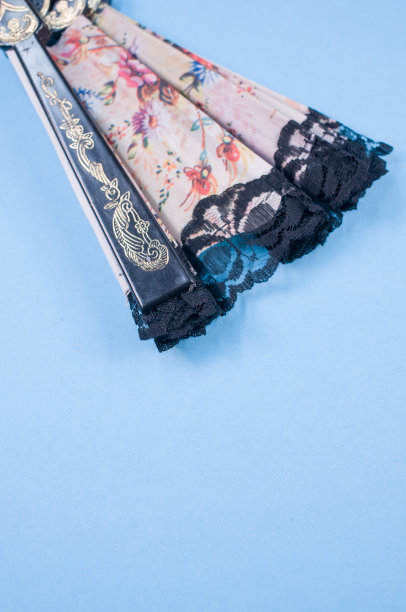 俯视图的折叠装饰花手扇孤立在蓝色背景与自由空间图片下载