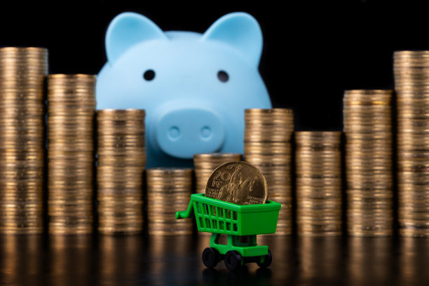 一枚20捷克克朗的硬币放在超市的微型购物车里，背景是成堆的金币图片下载