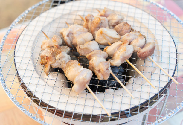单身男人在炭炉上烤烤鸡肉串图片下载