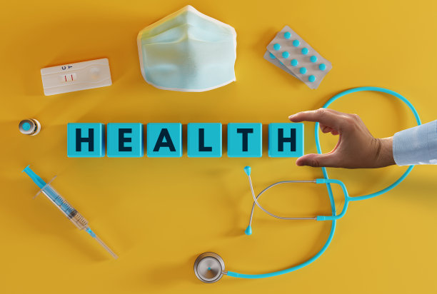 各种医疗设备，如注射器、听诊器、口罩、药片和用手放置的印有“健康”字样的木块。图片下载