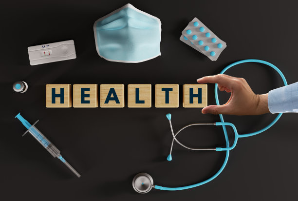 各种医疗设备，如注射器、听诊器、口罩、药片和用手放置的印有“健康”字样的木块。图片下载