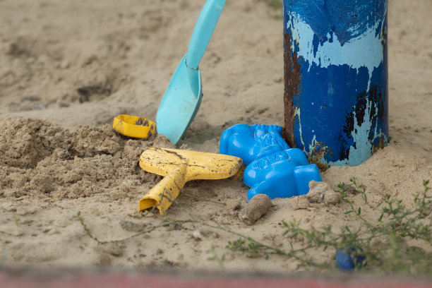 沙箱里的儿童玩具。被遗忘在废弃沙箱里的脏孩子玩具。毁灭和绝望的概念。图片下载