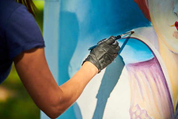 少女艺术家手握画笔，在白色画布上画出超现实的童话肖像图片下载