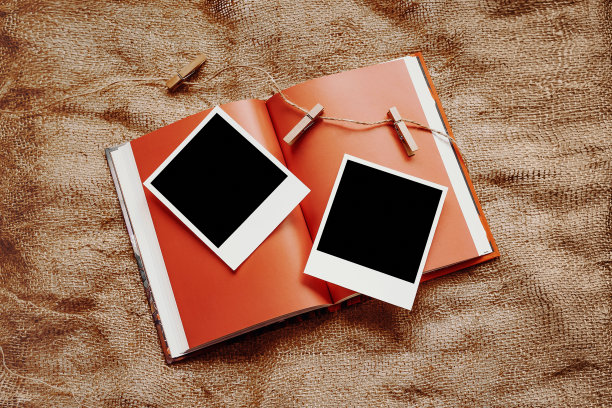 两张宝丽来卡片放在一本模型书上，背景是粗麻布图片下载