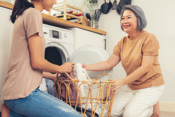 心满意足的女儿和母亲在家庭洗衣房一起工作。图片下载