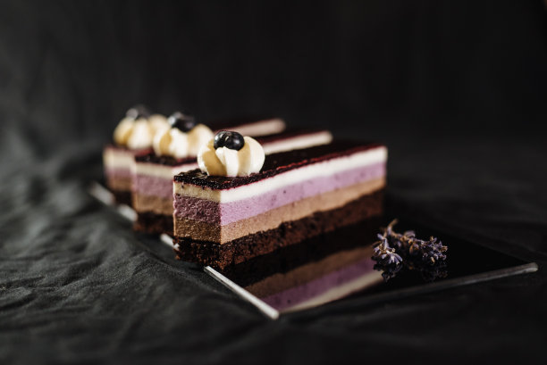 一款受欢迎的迷你甜点，黑色背景上有三颗巧克力。三个巧克力蛋糕图片下载