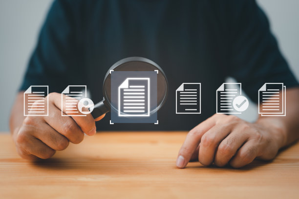 一个人用放大镜检查纸张。业务分析、审计、专业文档审查、查询和检查都是业务数据分析中使用的概念。图片下载