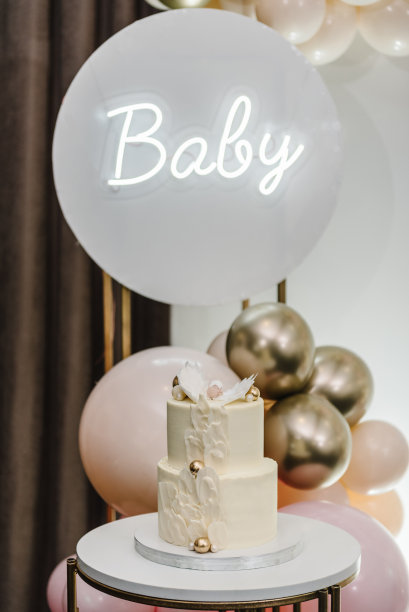 时尚蛋糕与数字天使。庆典洗礼概念。照片墙上的生日派对招待会。美味的接待。拱门上装饰着粉色、白色和金色的气球，短信宝贝。特写镜头。图片下载