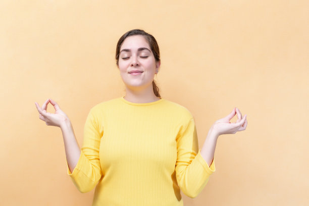 年轻的白人女孩手握瑜伽姿势放松冥想保持眼睛闭上图片下载