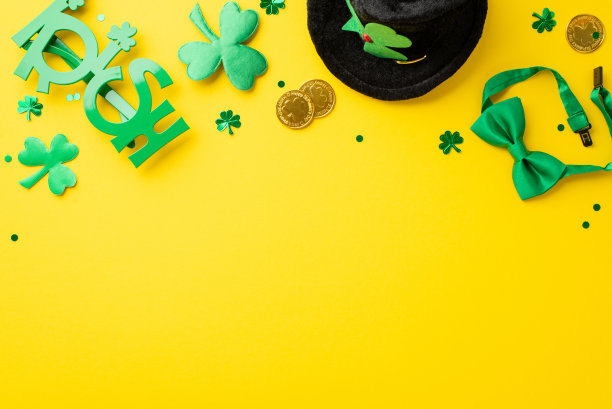 圣帕特里克节的概念。俯视图照片妖精帽子蝴蝶结金币爱尔兰派对眼镜三叶草和纸屑孤立的黄色背景与复制空间图片下载