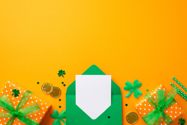 圣帕特里克节的概念。顶部视图照片的绿色打开信封与信礼盒与弓金币稻草和三叶草在孤立的橙色背景与复制空间图片下载
