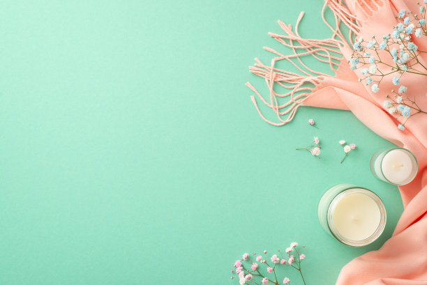 春天的审美观念。顶部查看照片的蜡烛，吉卜草花和粉红色舒适格纹在孤立的蓝绿色背景与复制空间图片下载