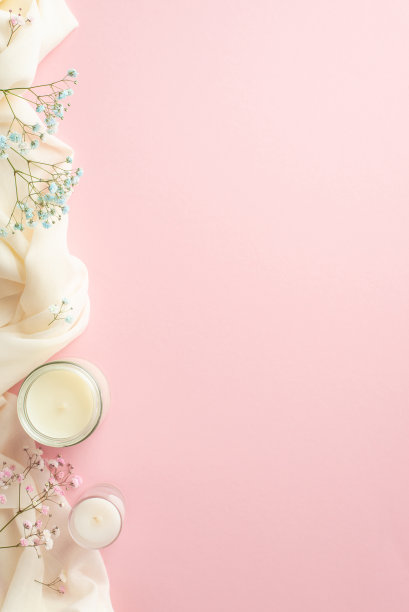 你好，春天概念。俯视图垂直照片蜡烛在眼镜粉红色和蓝色的吉卜草花和白色舒适格纹上孤立的浅粉色背景与空白图片下载