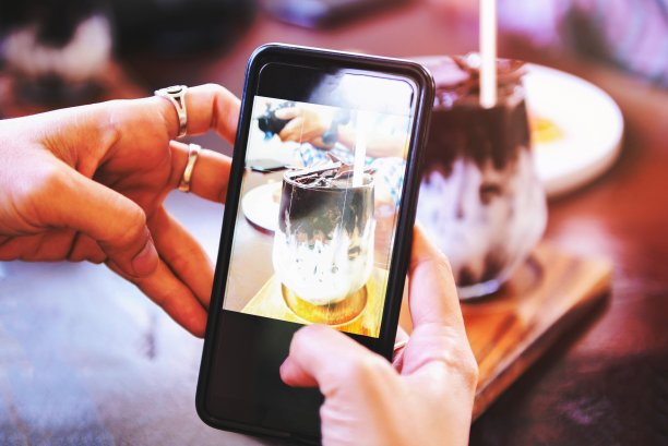 美食摄影女手用智能手机制作照片可可饮料和蛋糕-在餐厅用拍照智能手机拍摄食物照片并在社交网络上分享图片下载