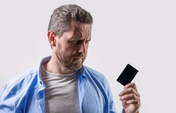 不开心的人持有商业借方。照片的人持有业务借记卡。Guy演艺圈借记图片下载
