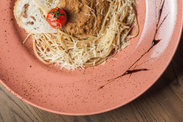 在盘子里撒上奶酪的意大利面食，配上条纹酱汁图片下载