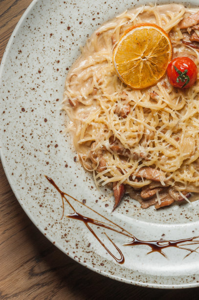 在盘子里撒上奶酪的意大利面食，配上条纹酱汁图片下载