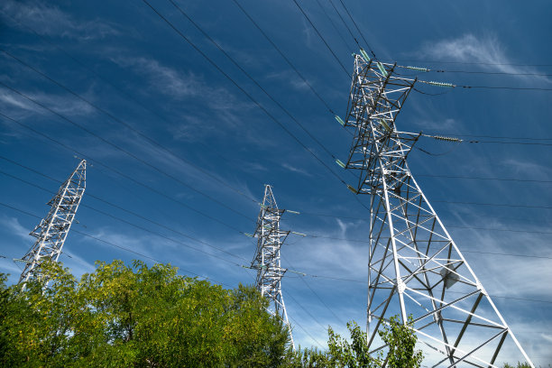 蓝天下的高压电输电电线塔。高压塔。电线和保险丝。能源业务。能源产业。能源进出口。图片下载