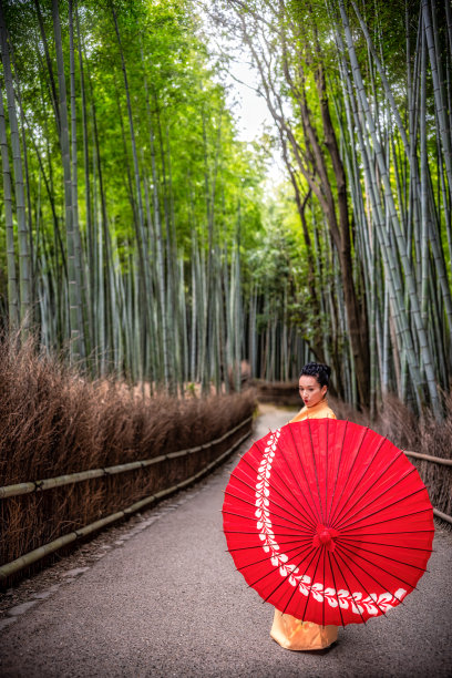 在京都的岚山竹林，一名身穿和服、打着红色雨伞的女游客。日本图片下载