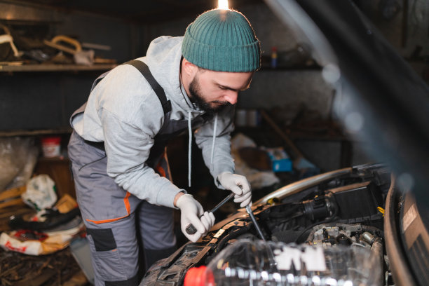 年轻的机械师在车库修车时用套筒扳手图片下载