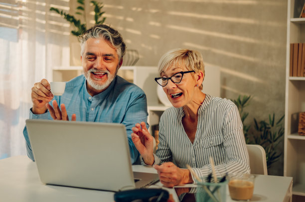 老夫妇在家里用笔记本电脑图片下载