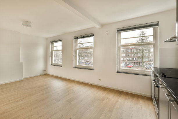 有三扇窗户和一个厨房的空客厅图片下载