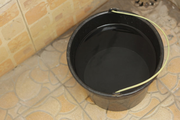 干净的水在黑色桶米黄色瓷砖墙背景图片下载