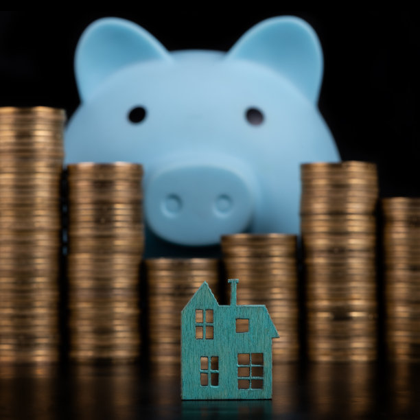 一个微型的象征性的蓝色木屋，背景是成堆的金币和一个储蓄罐图片下载