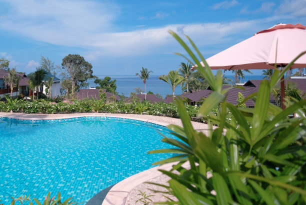 美丽的热带海滩度假村，有游泳池，在一座面向大海的山上。晴天、阴天有蓝天。夏天共鸣图片下载