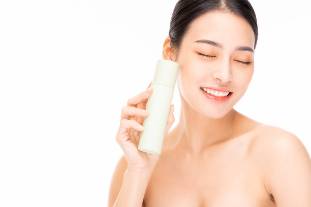 美丽的亚洲女性模特抱着化妆品瓶微笑美丽的亚洲女性展示护肤瓶产品美丽的脸身体肖像隔离在白色背景复制空间她闭上眼睛图片下载