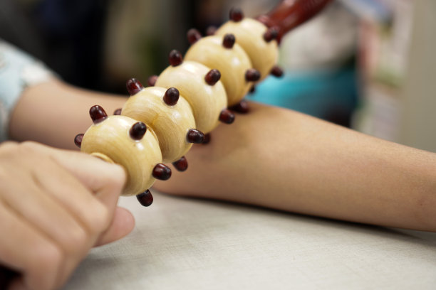 这幅图展示了如何使用在手臂肌肉上有特殊按摩按钮的瓜沙棒。图片下载