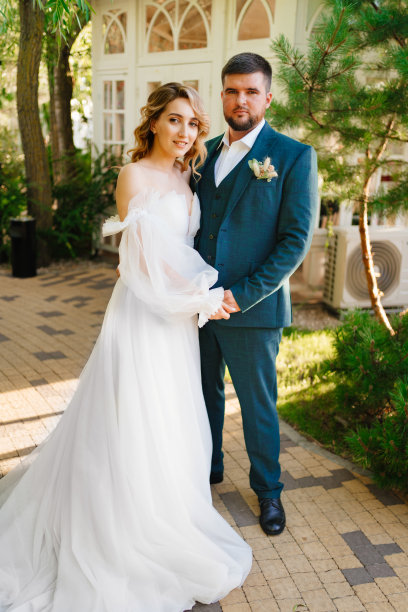 美丽而时尚的新娘和新郎在公园的小路上。图片下载