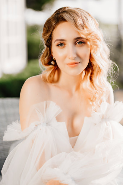 一个美丽的金发新娘在日落的白色礼服的肖像图片下载
