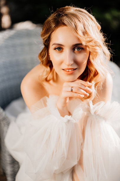 一个美丽的金发新娘在日落的白色礼服的肖像图片下载