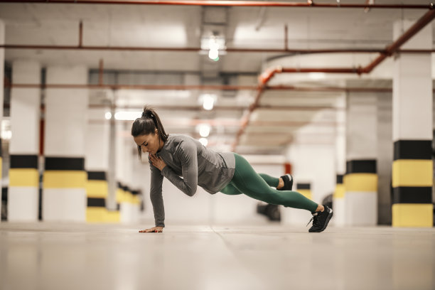 一位强壮的女运动员正在地下车库做力量训练。图片下载