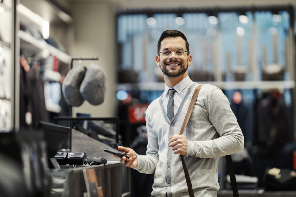 一个快乐的优雅的买家肖像使用无现金技术购买。图片下载