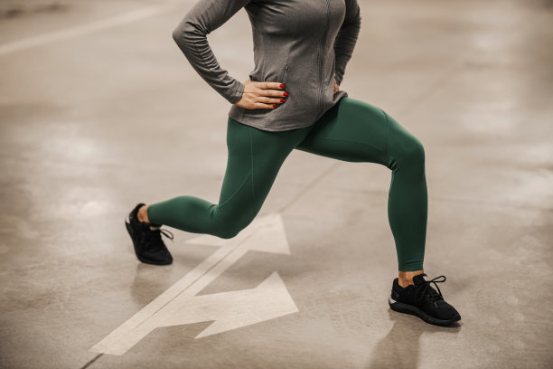 一个女运动员在地下车库做弓步和腿部锻炼的裁剪照片。图片下载