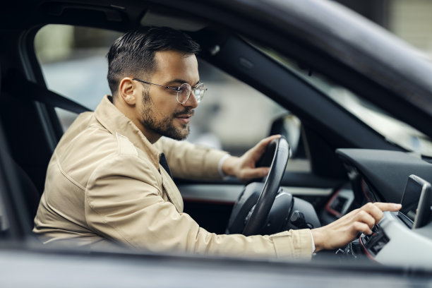 一位聪明的休闲通勤者正坐在车里调整gps，准备出差。图片下载