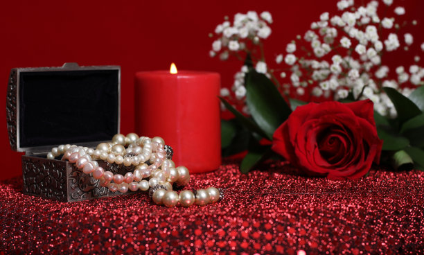 特写镜头的蜡烛和红玫瑰与香水在红丝绒背景图片下载