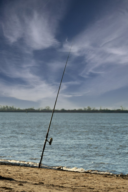 阳光明媚的日子里，在荒凉的河边钓鱼竿图片下载