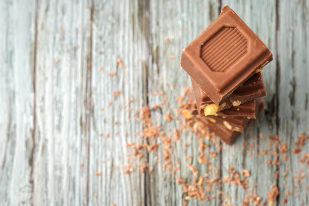 顶部视图的巧克力片与花生在木制背景与磨碎的巧克力图片下载