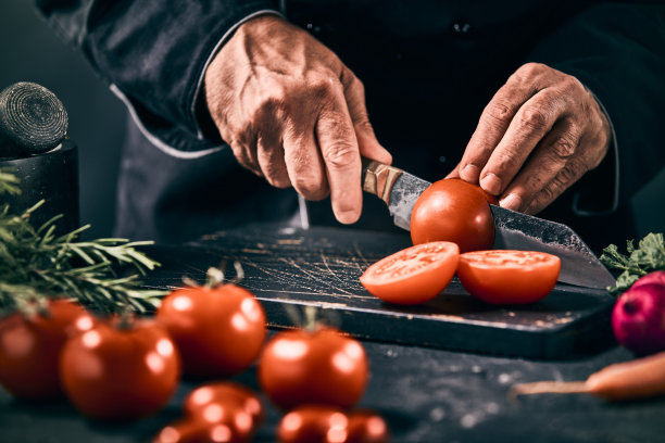厨师在菜板上切熟番茄图片下载