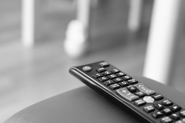 沙发上遥控器的灰度镜头图片下载
